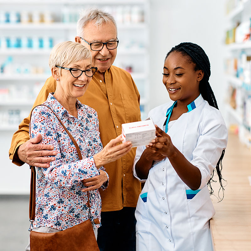 Pharmacist assisting two elderly patients